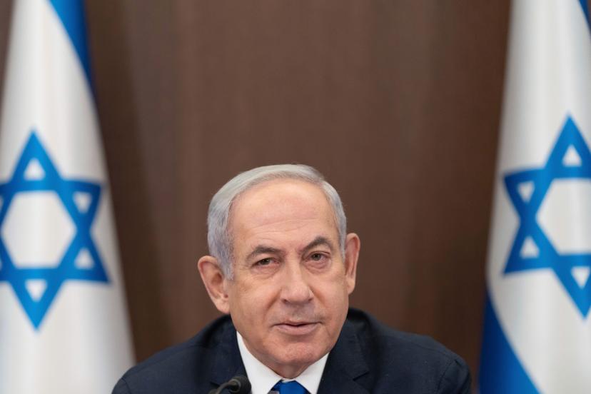 Israeli Prime Minister Netanyahu sitting between two Israeli flags