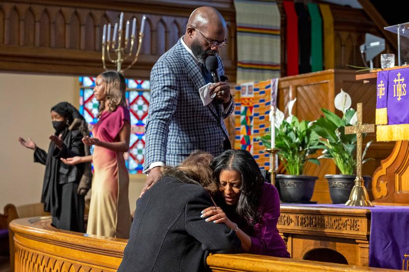 Rev. William H. Lamar IV, top, and Rev. Cozette Thomas, right, pray with a parishioner during Palm Sunday services at the Metropolitan AME Church 