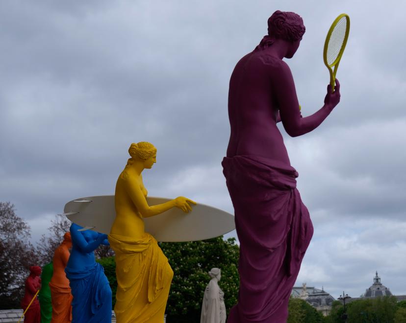 Six colorful Venus statues holding various sporting equipment in Paris