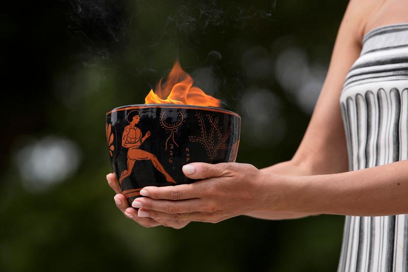 A performer holds a ceramic pot with the flame during the official ceremony of the flame lighting for the Paris Olympics, at the Ancient Olympia site, Greece, Tuesday, April 16, 2024. 