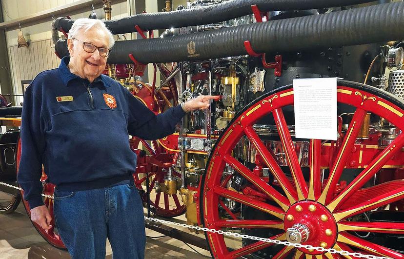 Gary Bohling next to antique fire fighting equipment