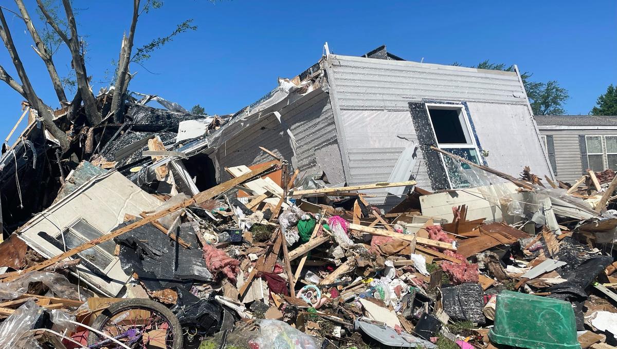 A torn up mobile home in a pile of rubble