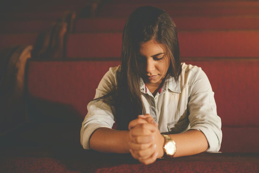 person praying in red pews