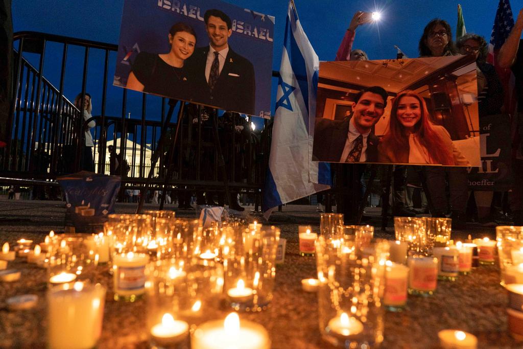 People gather to light candles in a makeshift memorial to honor Yaron Lischinsky and Sarah Milgrim who were killed as they left an event at the Capital Jewish Museum in Washington, during a candlelight vigil outside of the White House
