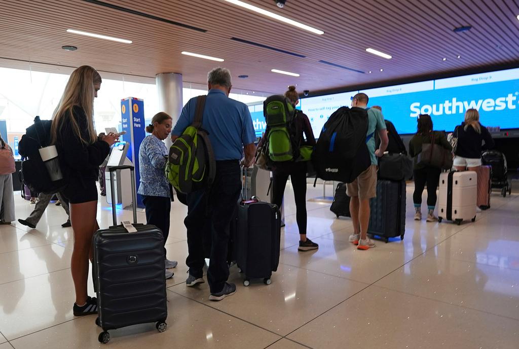 Travelers queue up at the check-in counters for their flights on Southwest Airlines in the main terminal of Denver International Airport 