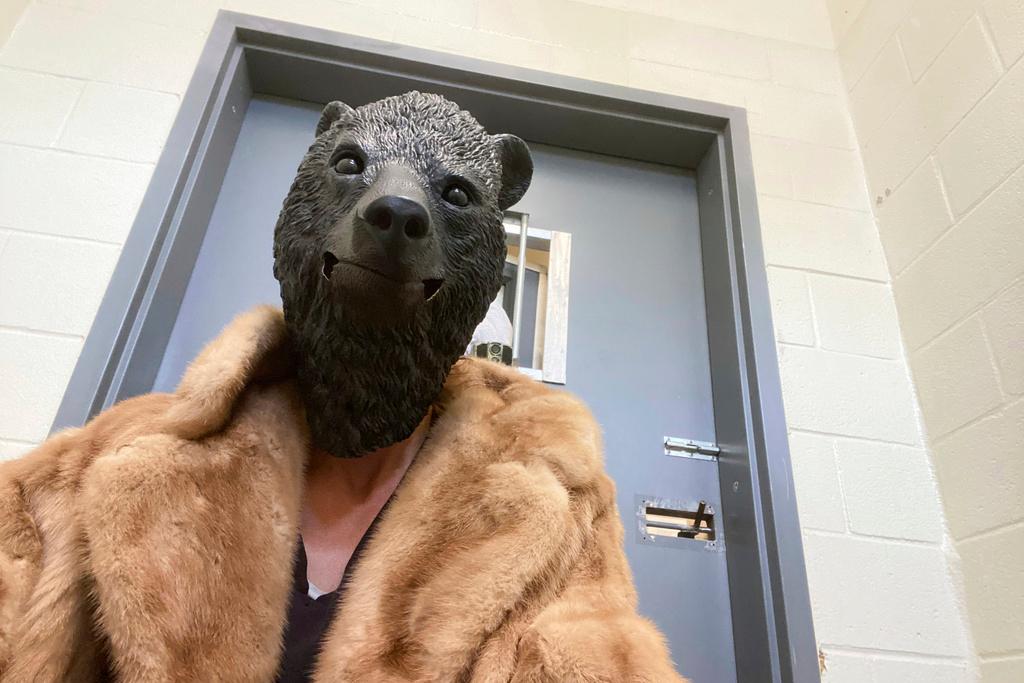 San Diego Humane Society employee wears a mask before interacting with a bear cub