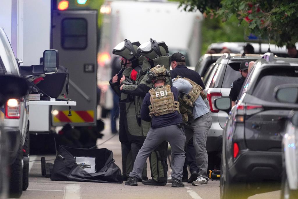 Law enforcement officials dress in protective gear to investigate after an attack on the Pearl Street Mall 