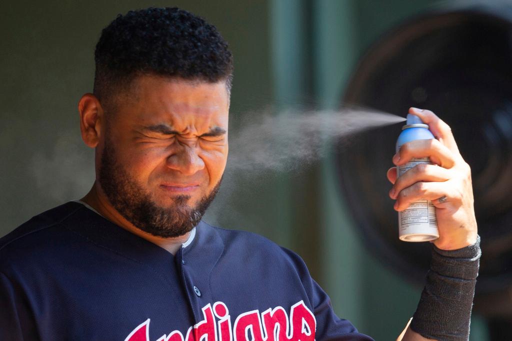 Cleveland Indians right fielder Melky Cabrera sprays sunscreen before a baseball game a