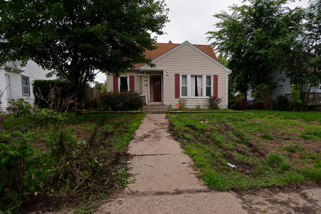 Tire marks from police vehicles mark the lawn of suspect Vance Luther Boelter's home in Minneapolis 