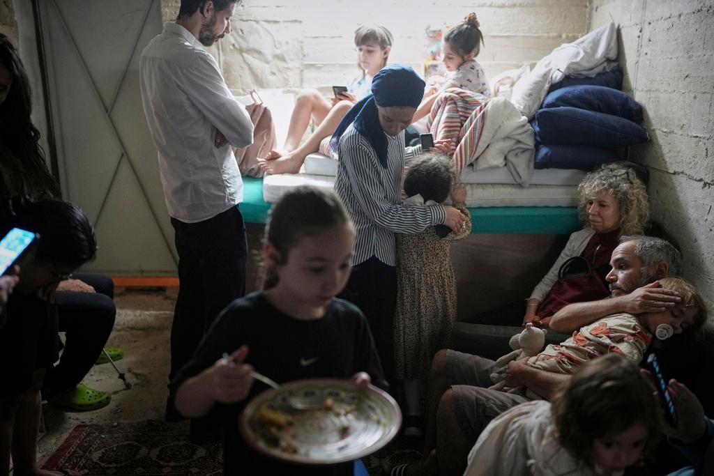 Israelis take shelter in a basement as a siren sounds a warning following missile launches from Iran
