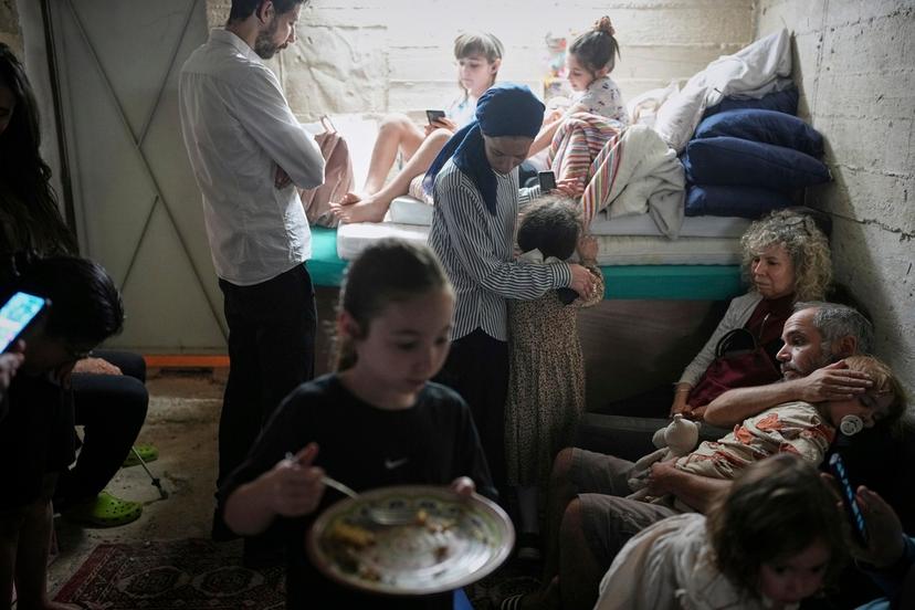 Israelis take shelter in a basement as a siren sounds a warning following missile launches from Iran