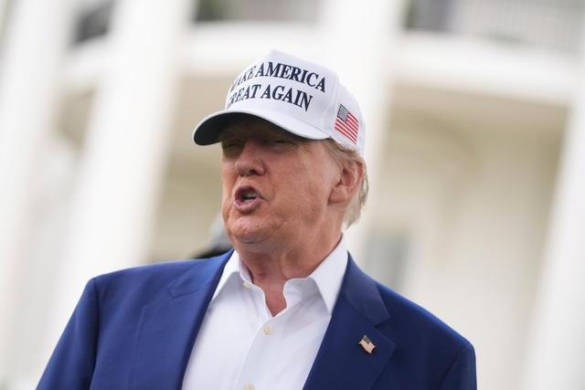 President Donald Trump speaks as a flag pole is installed on the South Lawn of the White House