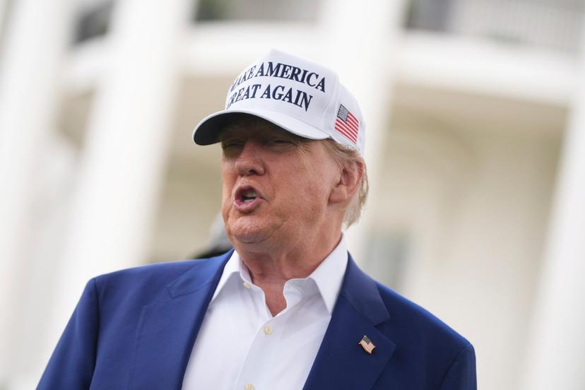 President Donald Trump speaks as a flag pole is installed on the South Lawn of the White House