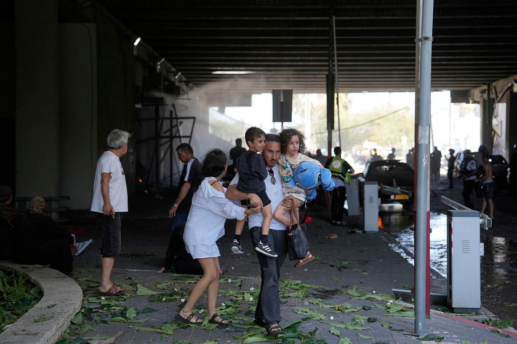 People evacuate after a missile launched from Iran struck in Haifa, Israel
