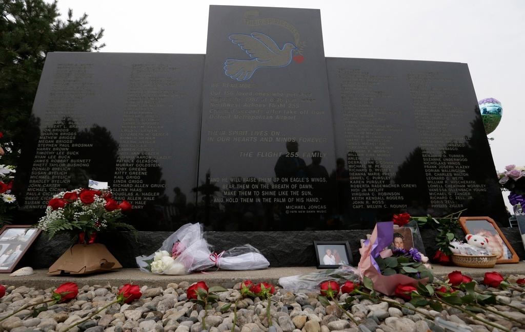 FILE - Flowers and pictures are shown at the memorial in Romulus, Mich., to mark the 25th anniversary of the crash of Northwest Airlines Flight 255 near Detroit Metropolitan Airport, Aug. 16, 2012. The MD-80 aircraft crashed in the Detroit suburb of Romulus, killing all 154 people aboard, except for a 4-year-old girl. Two people also died on the ground.