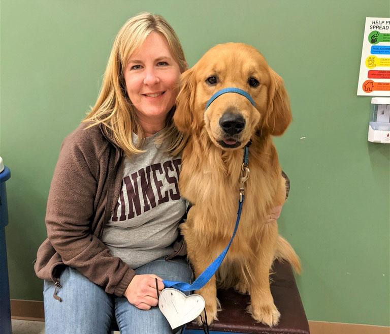 (2022) State Rep. Melissa Hortman poses with Gilbert, a golden retriever trained to be a service dog but eventually adopted by the Hortman family