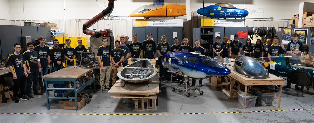 Members of Cedarville University's Supermileage team stand by its cars in the on-campus lab.