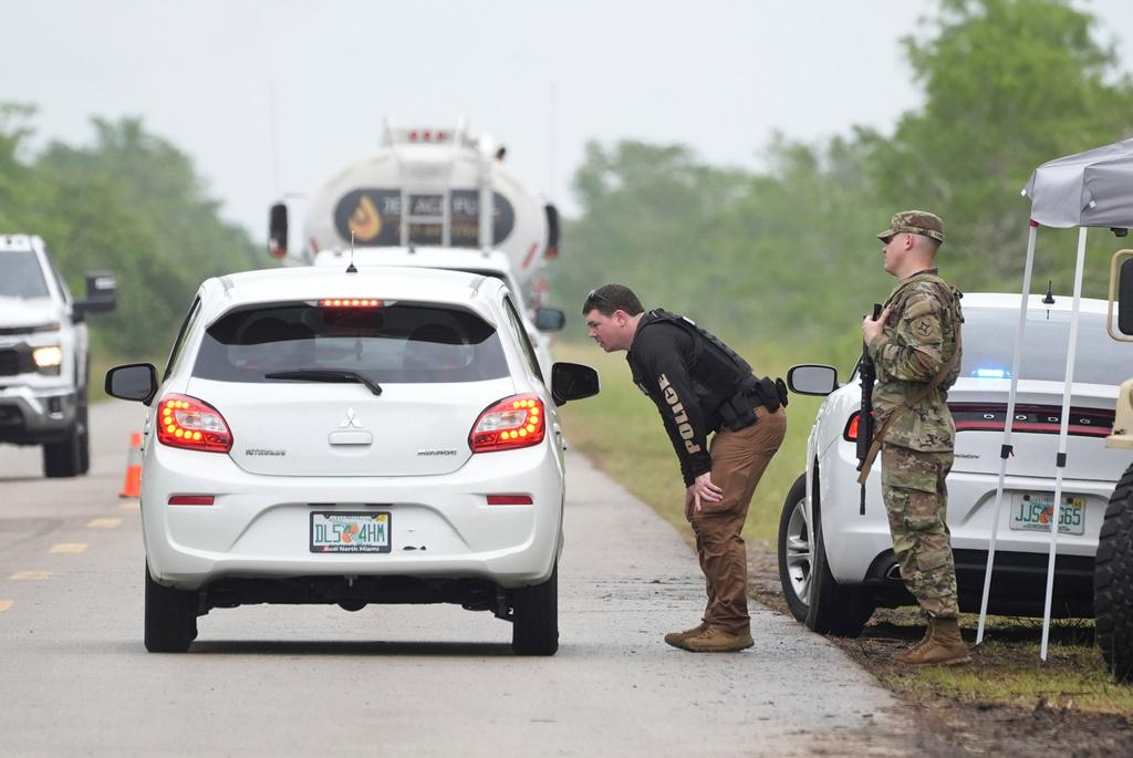 Police check cars arriving at the "Alligator Alcatraz," a new migrant detention facility at the Dade-Collier Training and Transition facility in Florida