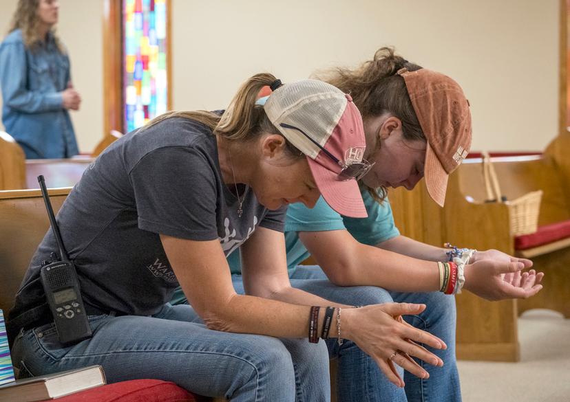 Ginger Turner, and her daughter, Hailey, right, pray during church services held at the Hunt Baptist Church on Sunday, July 6, 2025, in Hunt, Texas. Their small town sits on the bank of the Guadalupe River and was severely damaged 