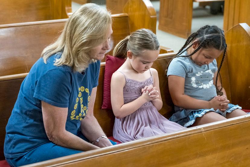 Layne Collis, sits and prays with her granddaughter, Karsyn Collis, right, and friend, Ellie Barrosos, 7, center, during church services held at Hunt Baptist Church after recent deadly flooding in Hunt, Texas