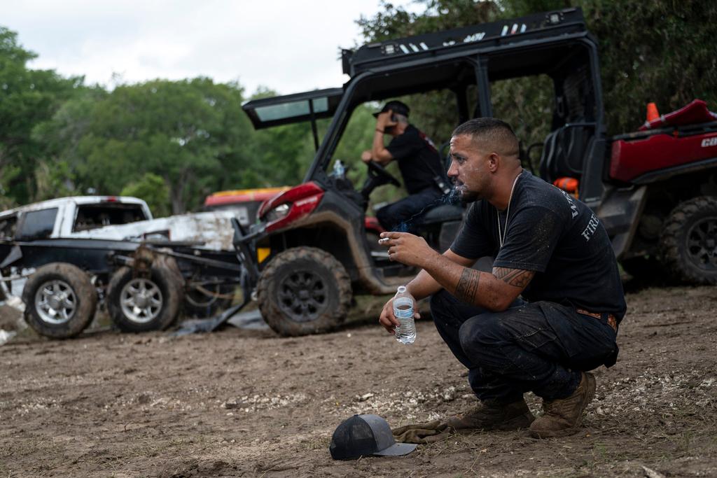 West Odessa Volunteer Firefighter Jed Wolske takes a smoke break while aiding in search and rescue efforts along the Guadalupe River, days after a flash flood swept through the area