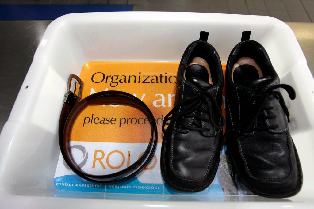 Belt and shoes sit in a trays with advertising that is being used in the safety screening of travelers done by the Transportation Security Administration