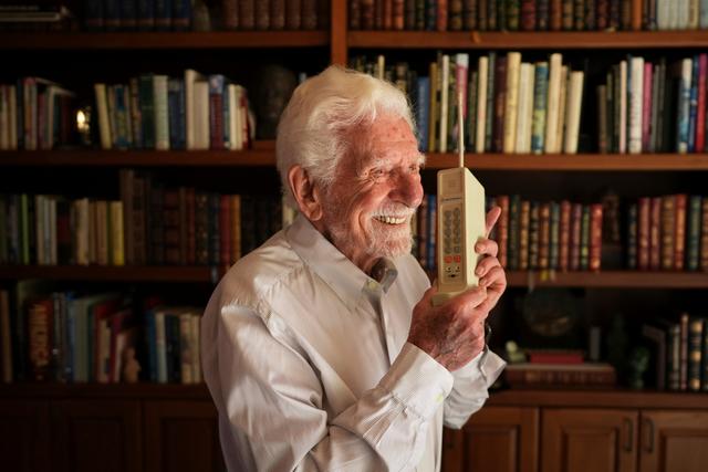 Martin Cooper, 96, who led the team that built the first mobile cellphone, shows a prototype of that phone at his home in San Diego