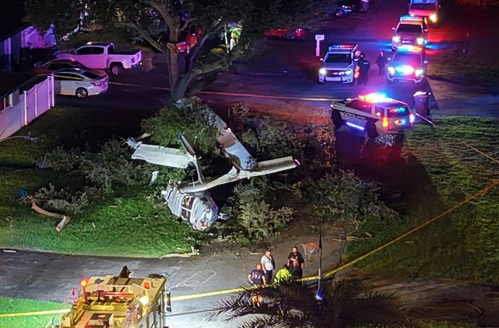 Emergency personnel work at the scene of the wreckage following a plane crash in a yard in the Pines Village community in Pembroke Pines, Fla.