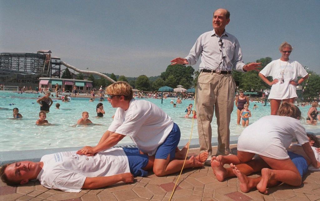 Dr. Henry J. Heimlich uses lifegaurds at Coney Island swimming pool in suburban Cincinnati on Friday, July 9, 1999, to demonstrate how the Heimlich maneuver can help save people from drowning.