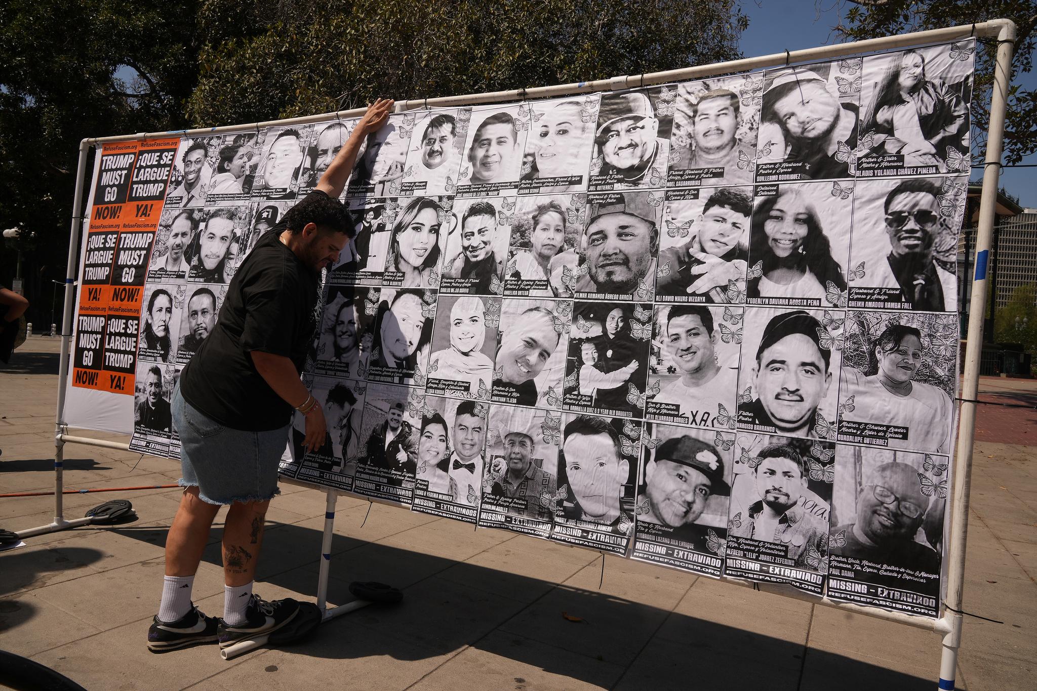 Man is setting up a display of pictures of people who've been detained by ICE