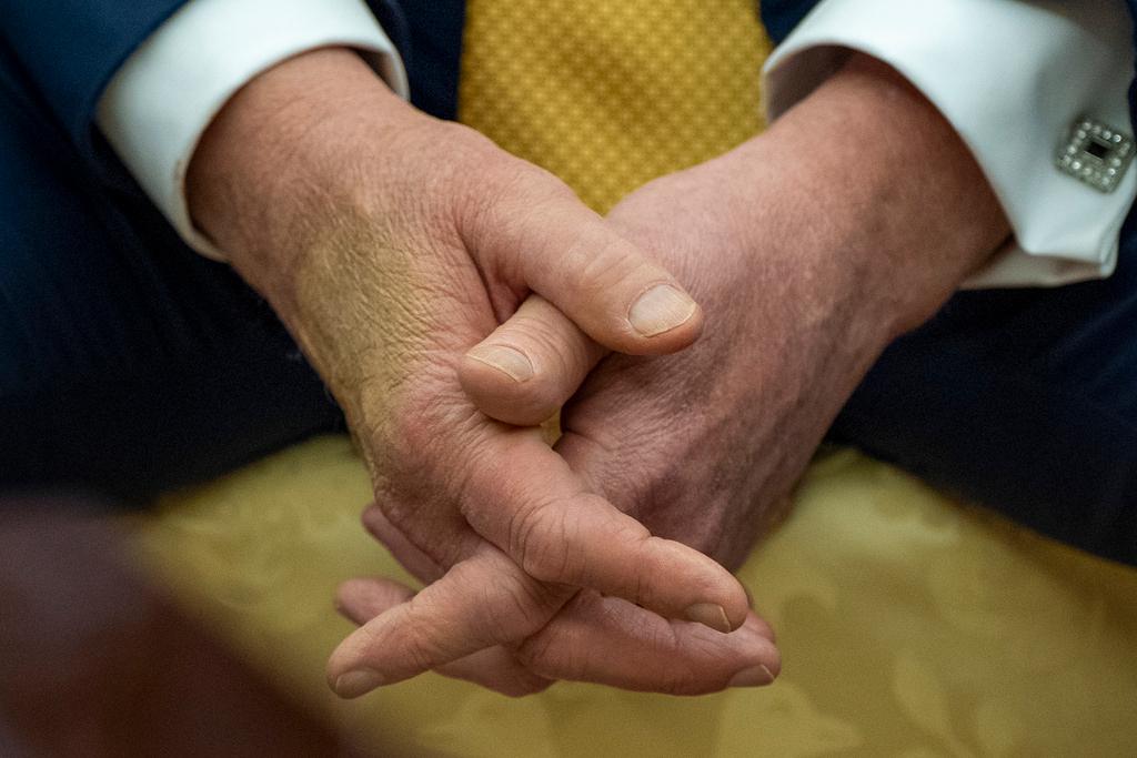 President Donald Trump sits with his hands interlocked as he and Bahrain's Crown Prince Salman bin Hamad Al Khalifa speak in the Oval Office of the White House, Wednesday, July 16