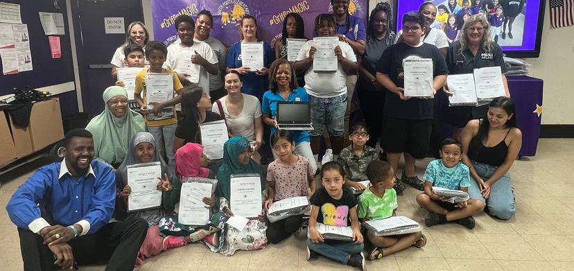 Brenda Powell (middle) with students and their new laptops