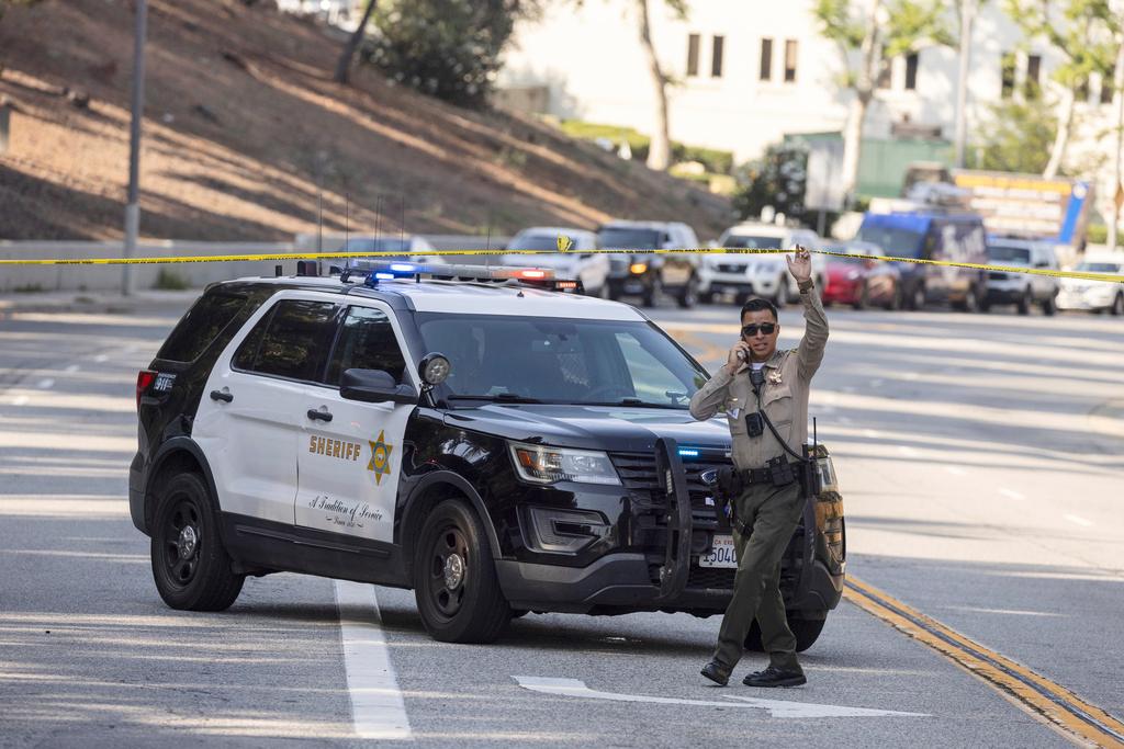 A sheriffs deputy monitors a street closure near the site of an explosion at the LA County Sheriff's Special Operations Bureau 