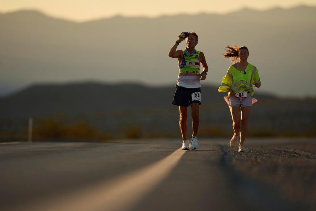 Danny Westergaard, left, cools of with water with pacing help from daughter Madison Westergaard as the sun rises during the Badwater 135 Ultramarathon