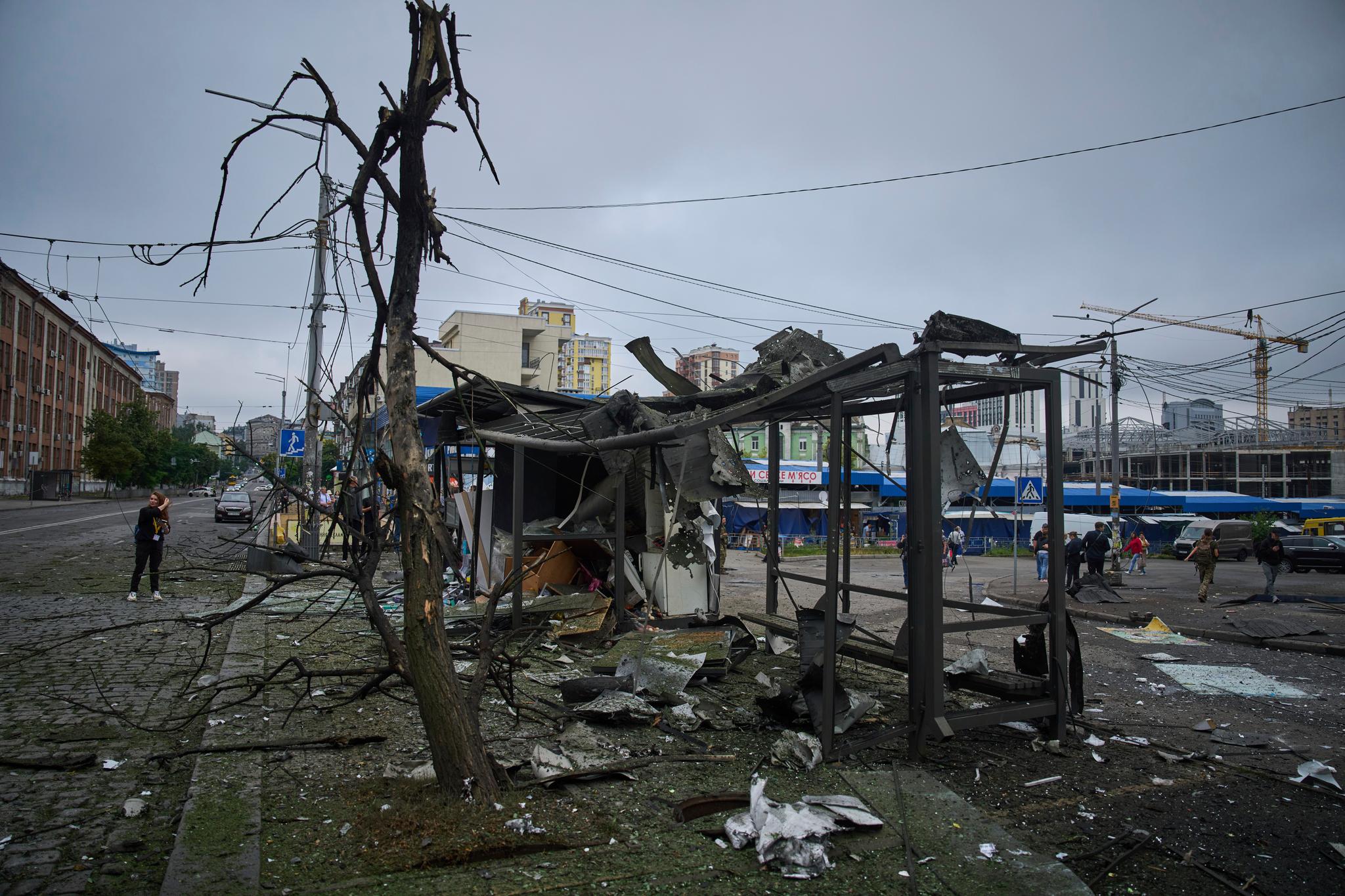 A bombed bus stop with twisted, burned metal.