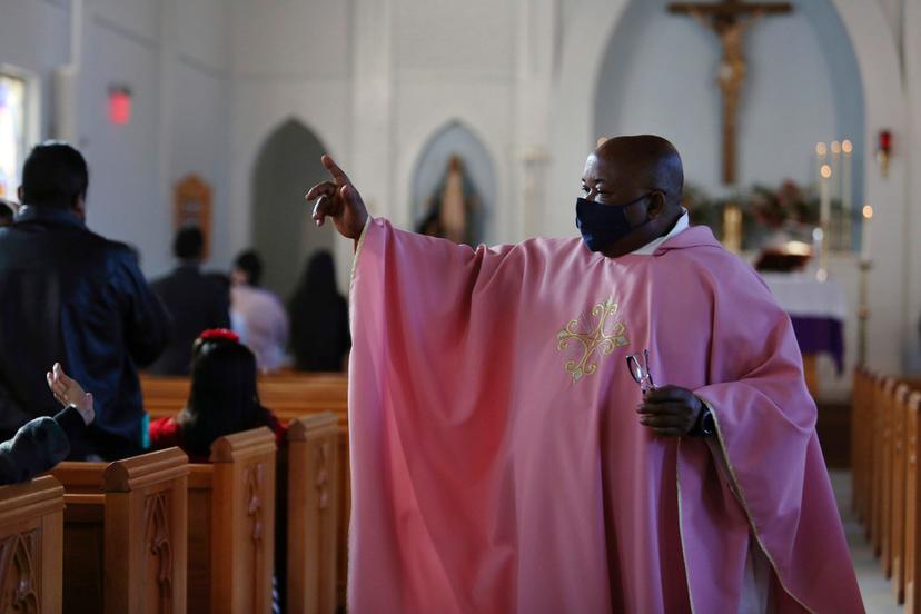 The Rev. Athanasius Abanulo waves to his parishioners after Mass at Immaculate Conception Catholic Church in Wedowee, Ala.