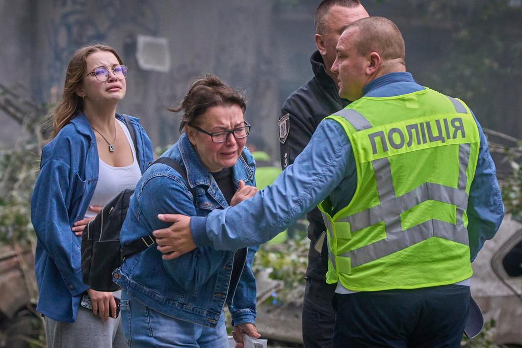 Women react outside a destroyed apartment building after a Russian missile attack in Kyiv