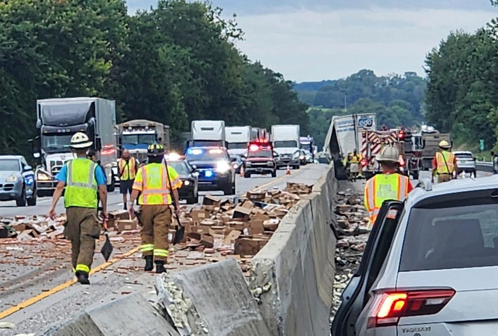 Crews clean up a truckload of hot dogs that spilled out of a tractor-trailer along Interstate 83 in Shrewsbury, Pa.