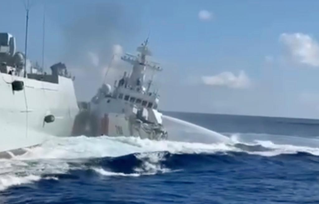 A damaged Chinese Coast Guard ship, right, is seen beside a Chinese Navy vessel, left, after they accidentally collided while chasing a Philippine fisheries boat 