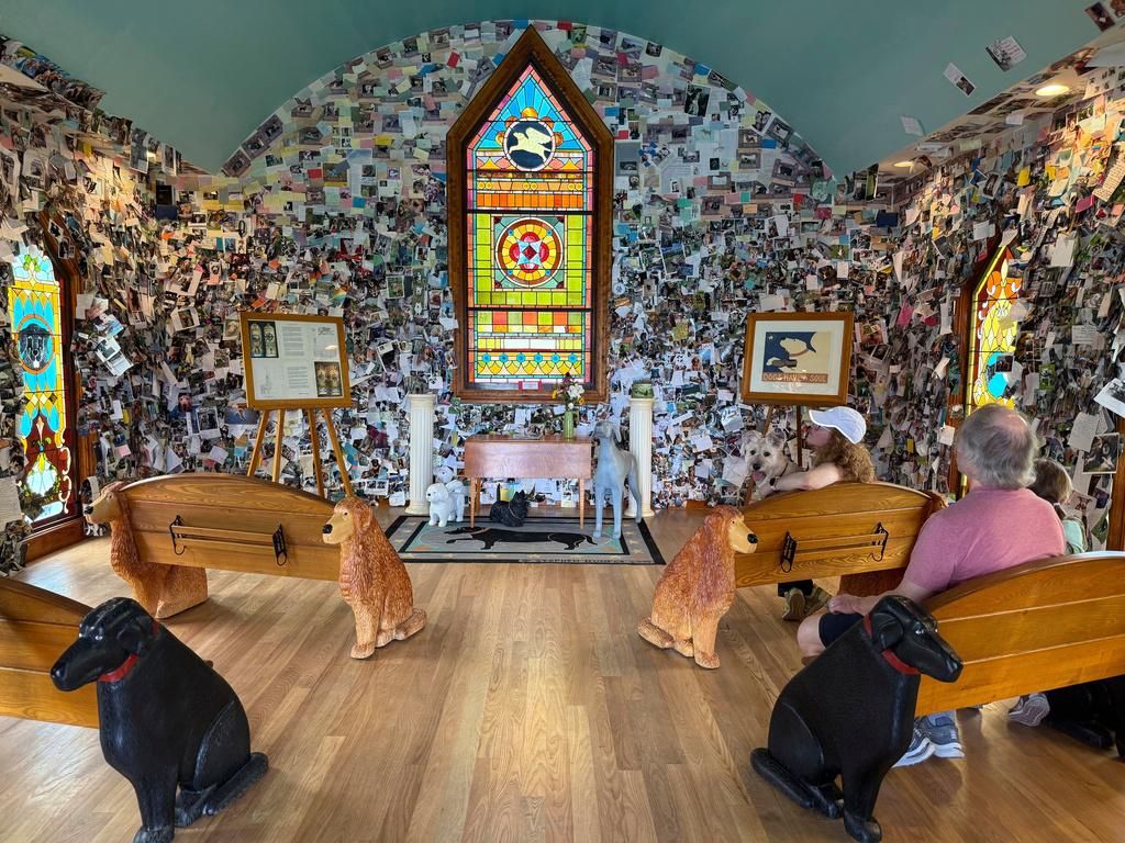Visitors sit in the Dog Chapel at Dog Mountain, a 150-acre dog park created by Vermont folk artist Stephen Huneck