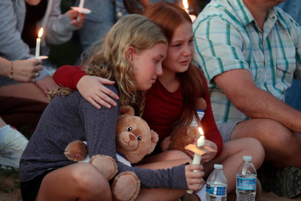 People gather at a vigil at Lynnhurst Park after a shooting at the Annunciation Catholic School