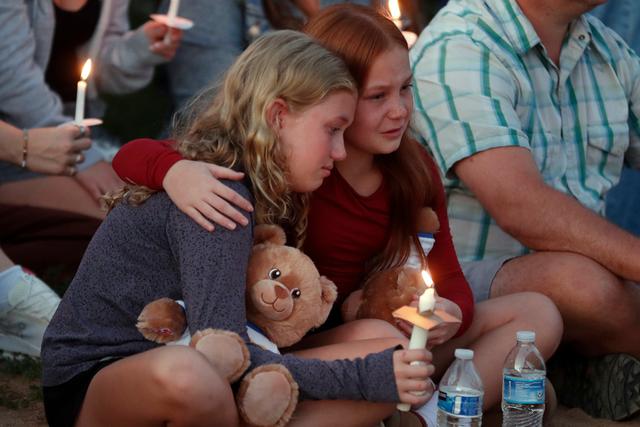 People gather at a vigil at Lynnhurst Park after a shooting at the Annunciation Catholic School