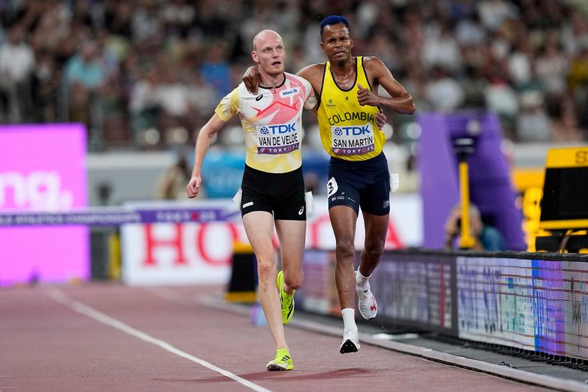 Colombia's Carlos San Martin and Belgium's Tim Van De Velde help each other to the nine during a men's 3,000 meters steeplechase heat at the World Athletics Championships in Tokyo