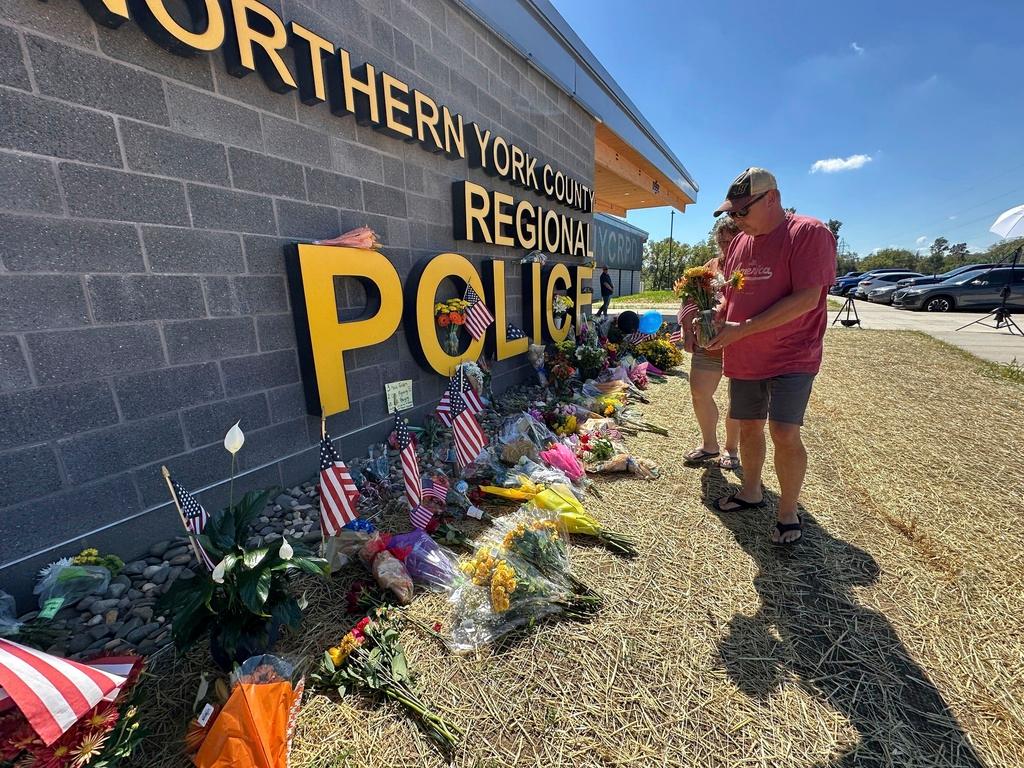 A memorial for police officers killed in a shooting is shown outside the Northern York County Regional Police Department in York, Pa. 
