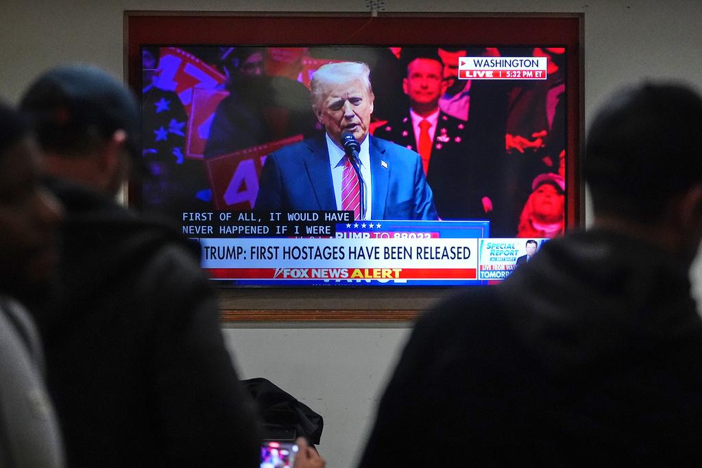 People inside of a restaurant watch TV with subtitles