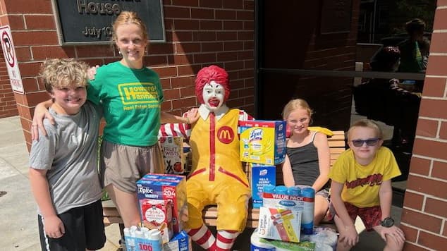 Danielle Shearer poses with her children and Ronald McDonald outside the Pittsburgh Ronald McDonald House Charities after delivering a donation to support families staying at the facility.