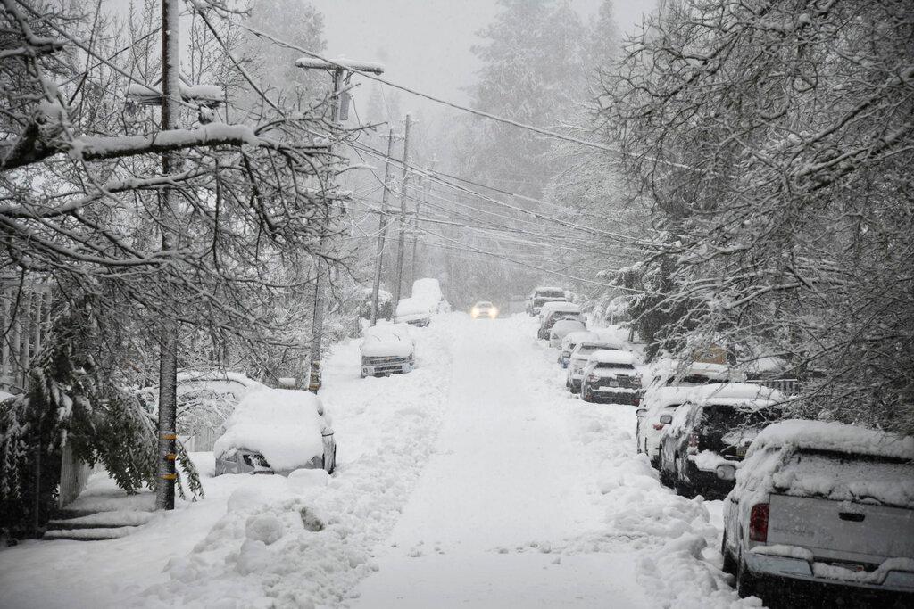 A vehicle attempts to drive along snow-covered Conaway Avenue in downtown Grass Valley, Calif.