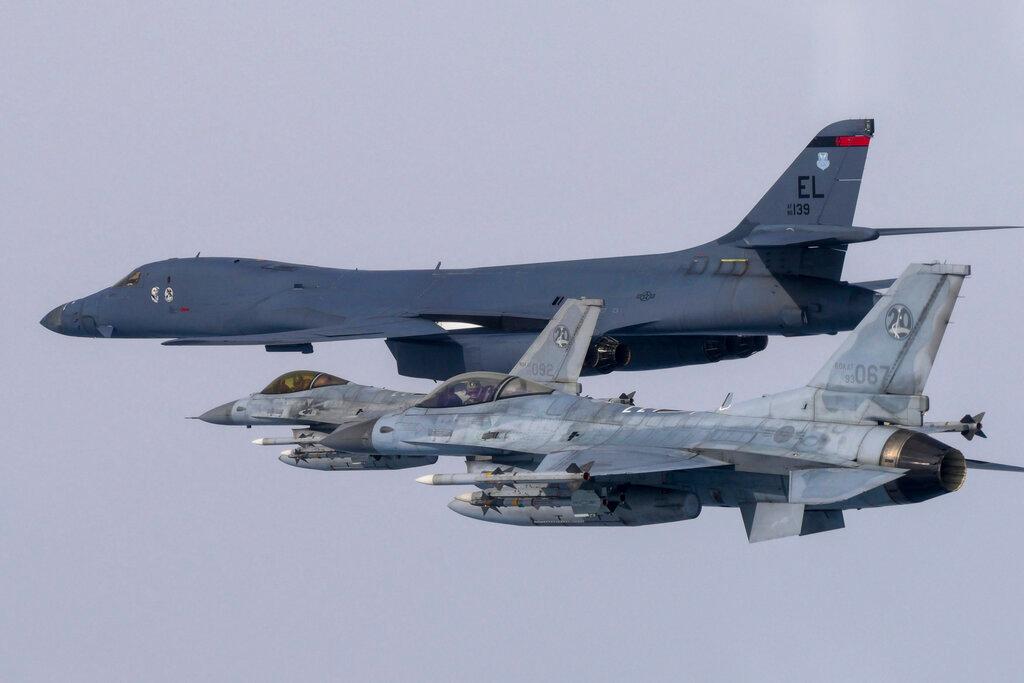 In this photo provided by South Korea Defense Ministry, a U.S. Air Force B-1B bomber, top, flies in formation with South Korea's Air Force KF-16 fighters over the South Korea Peninsula during a joint air drill in South Korea.