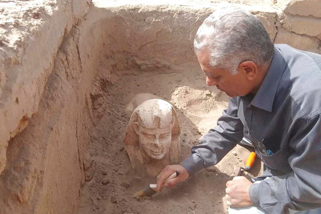 In this undated photo distributed Monday, March 6, 2023, by the Egyptian Ministry of Tourism and Antiquities, a sphinx statue believed to be made in the likeness of a Roman emperor is uncovered from an archaeological site in Qena, Egypt.