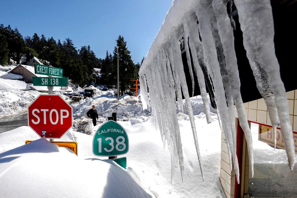 Snowfall surrounds businesses in Crestline, Calif.